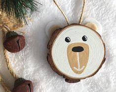 a wooden ornament with a bear face on it and two acorns