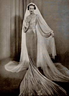 an old black and white photo of a woman in a wedding dress with a veil on her head