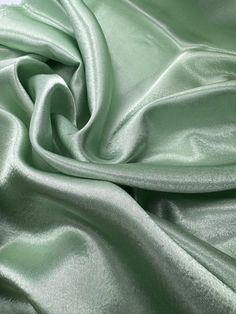 Sage green crepe back satin This high-quality satin fabric is a perfect choice for any project that requires a touch of elegance and sophistication. The 58-inch width make it suitable for a wide range of applications, from apparel to home decor and crafts. The fabric comes in a beautiful shade of silver, which adds a classy and luxurious feel to any design. Ideal for use in bridal dresses, blazers, curtains, and even marquees, this shiny crepe back satin fabric offers excellent drape and durability. Whether you are a professional designer or a DIY enthusiast, this fabric is sure to inspire your creativity and help you create stunning and unique creations. Get your hands on this gorgeous fabric today and let your imagination run wild! Delivery All items are dispatched within 1-2 working day Deco Dress, Shiny Dresses, Sequin Fabric, Green Satin, Gorgeous Fabrics, Satin Fabric, Sage Green, Bridal Dresses, Satin