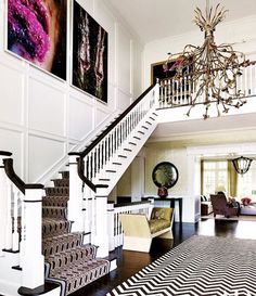 a staircase in a house with pictures on the wall and carpeted flooring around it