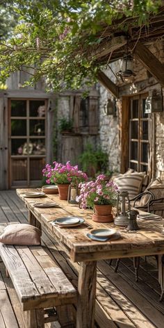 a wooden table sitting on top of a wooden floor next to a bench and flowers