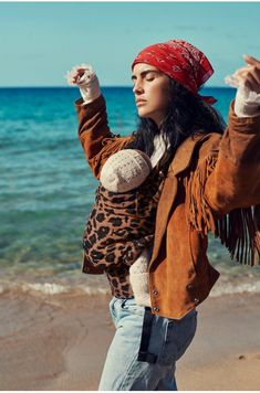 a woman standing on top of a beach next to the ocean