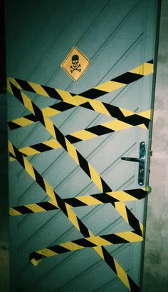 a door decorated with black and yellow hazard tape