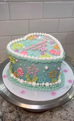 a decorated cake sitting on top of a metal platter