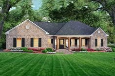 a brick house with black shutters and green grass