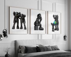 three black and white pictures hang on the wall above a bed in a room with gray furniture