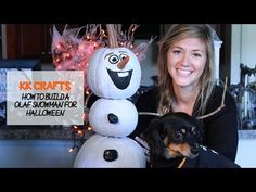 a woman holding a dog next to a snowman