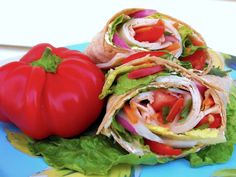 there is a wrap with lettuce, tomatoes and other vegetables on the plate