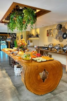 a table with food on it and hanging plants in the background at a buffet area