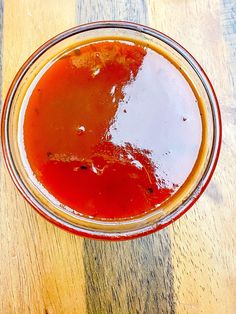 a glass filled with liquid sitting on top of a wooden table