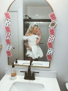 a woman taking a selfie in front of a mirror with playing cards on it