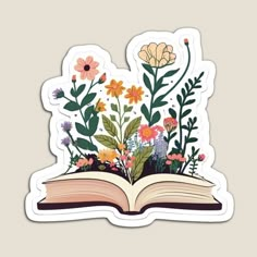 an open book with flowers and leaves on it is shown in the shape of a sticker