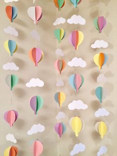 paper hot air balloons are hanging from the ceiling with clouds in the sky above them