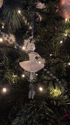 a glass ornament hanging from a christmas tree with lights on it's branches