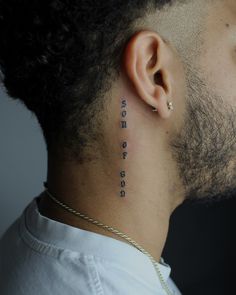 a man with a tattoo on his neck and behind his ear that reads, roses