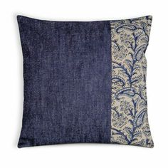 a blue and white pillow with an embroidered design on the front, two contrasting sides