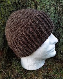 a knitted hat sitting next to a tree