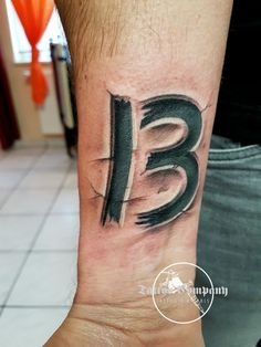 a man's wrist tattoo with the letter b in black and grey ink on it