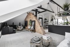 a living room filled with furniture and a fire place in the middle of a loft