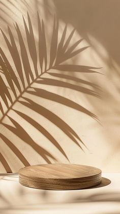 a wooden plate sitting on top of a white floor next to a palm tree shadow