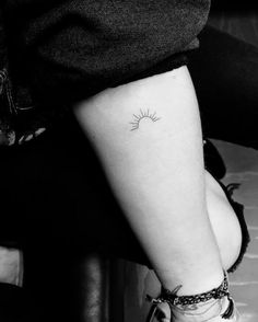 a small sun tattoo on the ankle