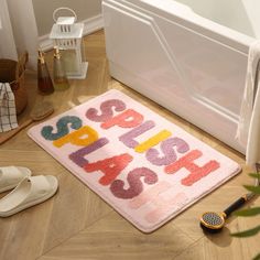 a bath mat that says happy birthday next to slippers and shoes on the floor