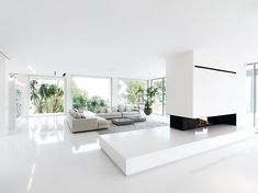 a large white living room with lots of windows and furniture on the floor in front of it