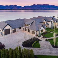 this is an aerial view of a house on the water with mountains in the background