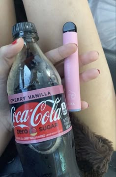 a woman is holding a coca - cola bottle and a pink pen