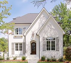 a white house with gray shutters and windows