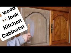 a person holding a wooden cabinet with the words wood look kitchen cabinets written on it