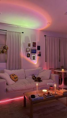 a living room filled with furniture and lit up by colorful lights on the ceiling above