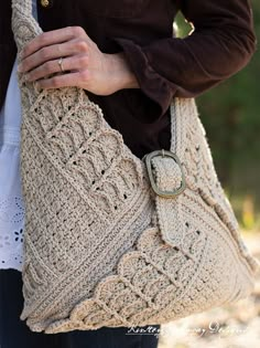 a woman is holding a crocheted purse