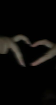 a blurry photo of a person's hand holding an object in the dark