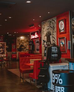 a restaurant with red chairs and posters on the wall