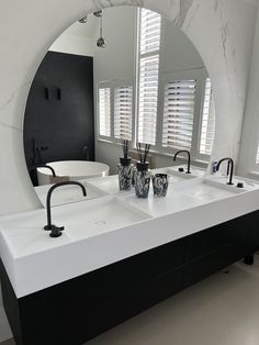 a bathroom with two sinks and a large mirror in the middle of it's wall