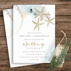 a wedding card with starfishs and watercolor paint on it, sitting next to a