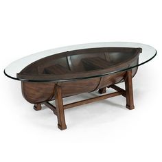 a table with a glass top and wooden frame on it's legs, in the shape of a boat