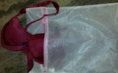 a bra that is sitting on top of a piece of cloth with a pink ribbon around it