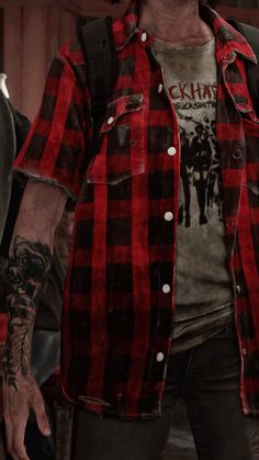 a man in a red and black checkered shirt is holding his hand out to the side