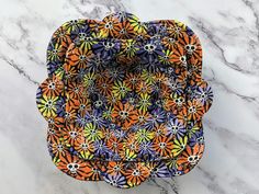 an orange and purple flowered tray sitting on top of a marble counter