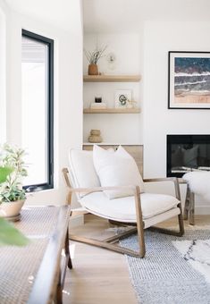 a living room filled with furniture and a flat screen tv mounted on a wall next to a window