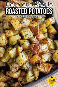 roasted potatoes with herbs and garlic in a black bowl on top of a woven table cloth