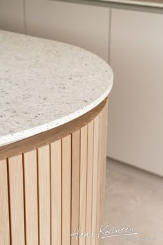 a counter top in the middle of a kitchen with white cupboards and cabinets behind it