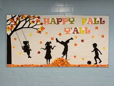 a happy fall y'all bulletin board hanging on a wall in a school hallway