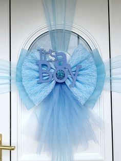 a door hanger with the word it's a boy in blue on it