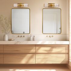 there are two mirrors on the wall above the sinks in this bathroom, one is gold and the other is white