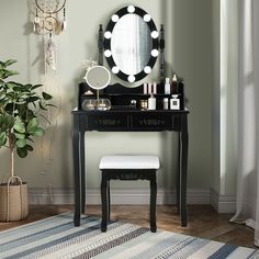 a vanity with a mirror, stool and potted plant