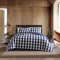 a bed in a room with wooden walls