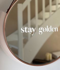 a round mirror with the words stay golden on it